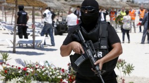 A hooded Tunisian police officer stands guard at the scene of the terror attack on Sousse. (Abdeljalil Bounhar /AP)