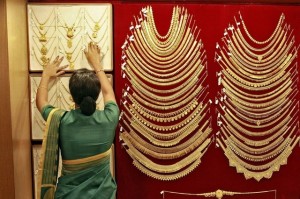A saleswoman arranges a gold necklace inside a jewellery showroom in Kochi, India. Sivaram V / Reuters